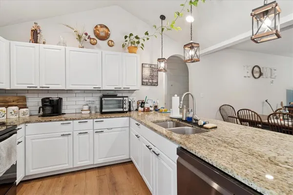 a kitchen with stainless steel appliances granite countertop a sink a stove and cabinets