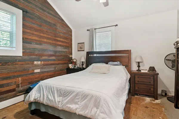 a bedroom with a bed and dresser with windows