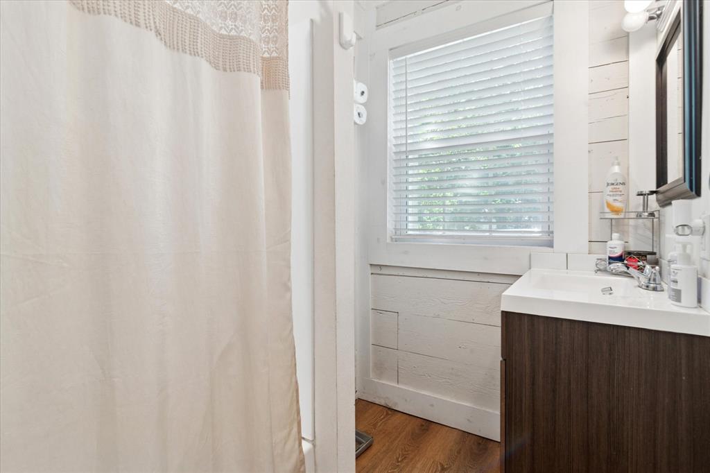 1102 West 12th Street Bonham, TX 75418 - Photo 20 of 27 Bathroom featuring a shower with shower curtain, vanity, and dark wood finished floors