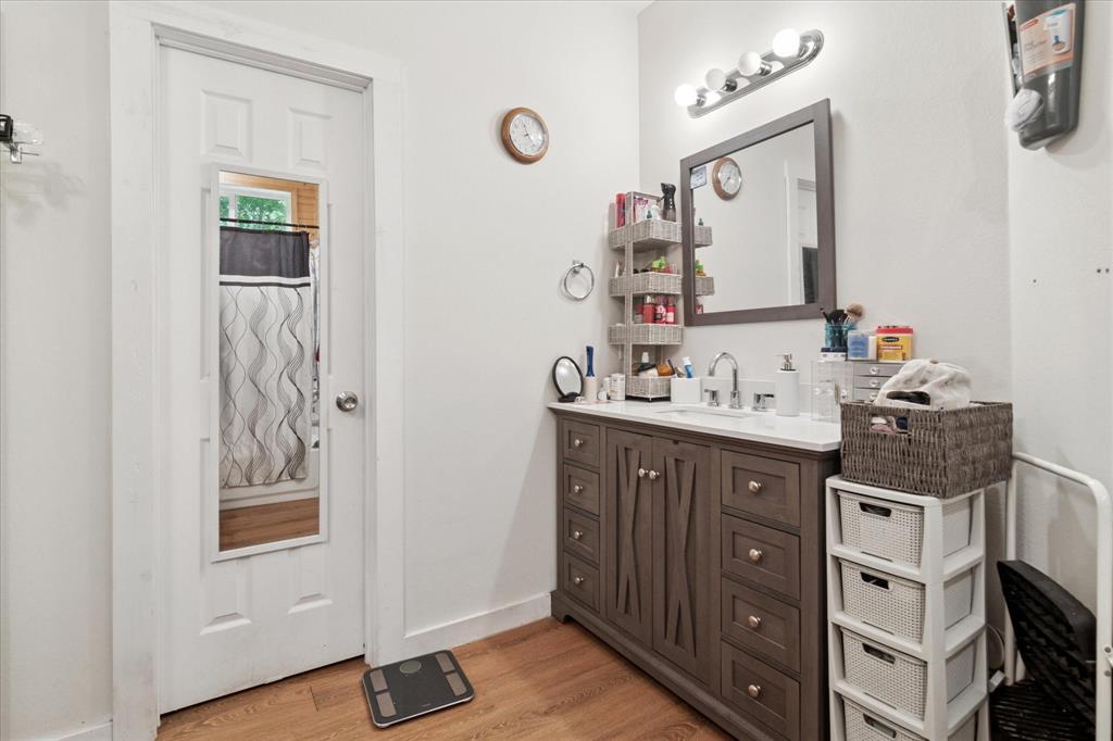 1102 West 12th Street Bonham, TX 75418 - Photo 21 of 27 Bathroom featuring vanity and light wood-style flooring