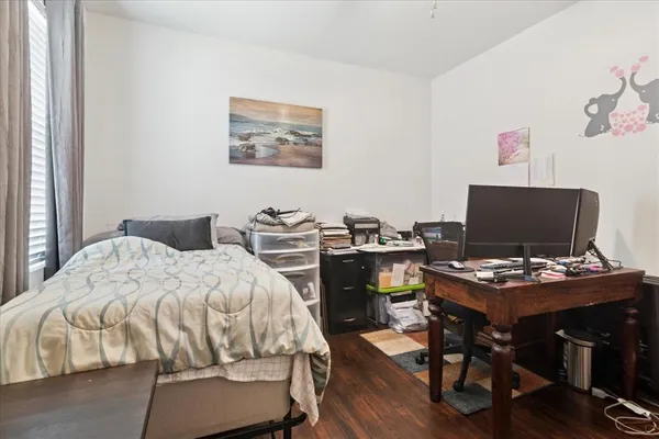a bedroom with a bed and a computer on a table
