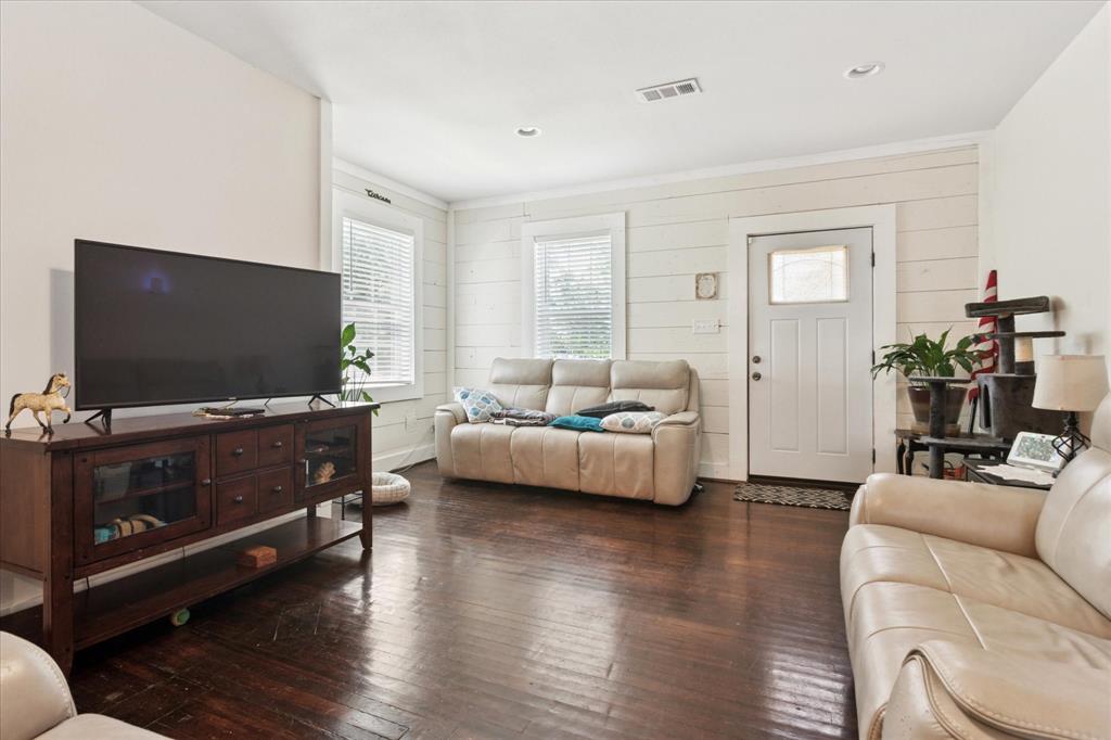 1102 West 12th Street Bonham, TX 75418 - Photo 8 of 27 Living area with dark wood-style floors, wooden walls, and recessed lighting