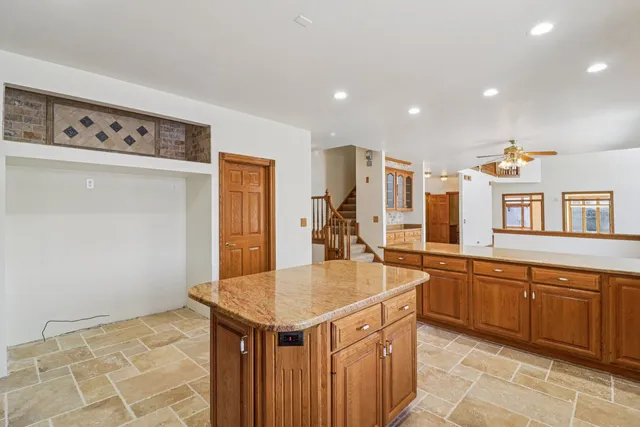 a spacious bathroom with a granite countertop sink and a mirror