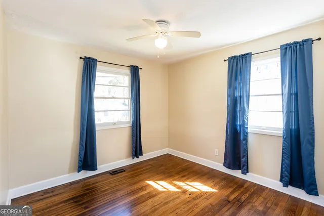 a view of empty room with window and wooden floor