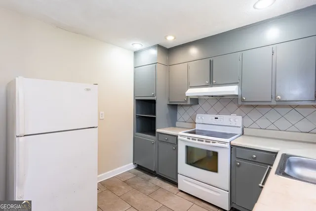 a kitchen with a stove top oven and refrigerator