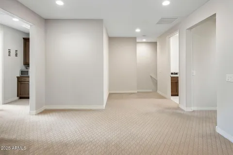 an empty room with wooden floor and entrance to ceiling window