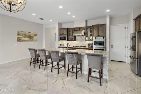 a kitchen with stainless steel appliances kitchen island granite top and refrigerator