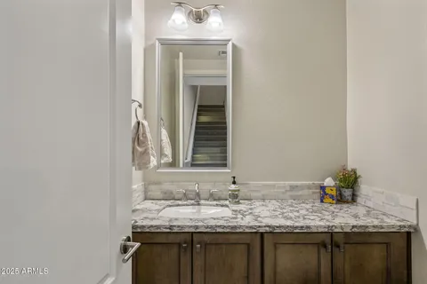 a bathroom with a granite countertop sink and a mirror