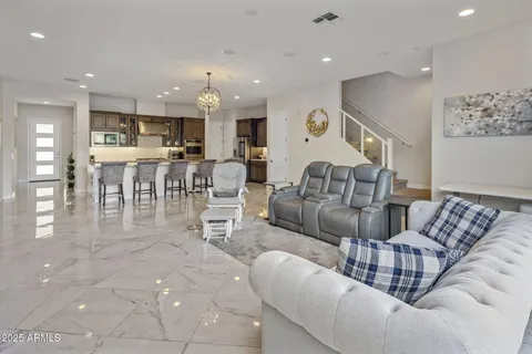 a living room with furniture and a dining table with kitchen view