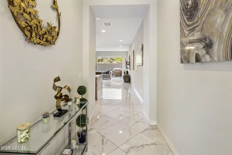 a hallway with painting on the wall and a potted plant