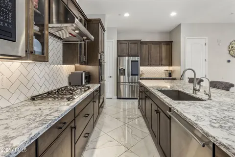 a kitchen with granite countertop stainless steel appliances and a sink
