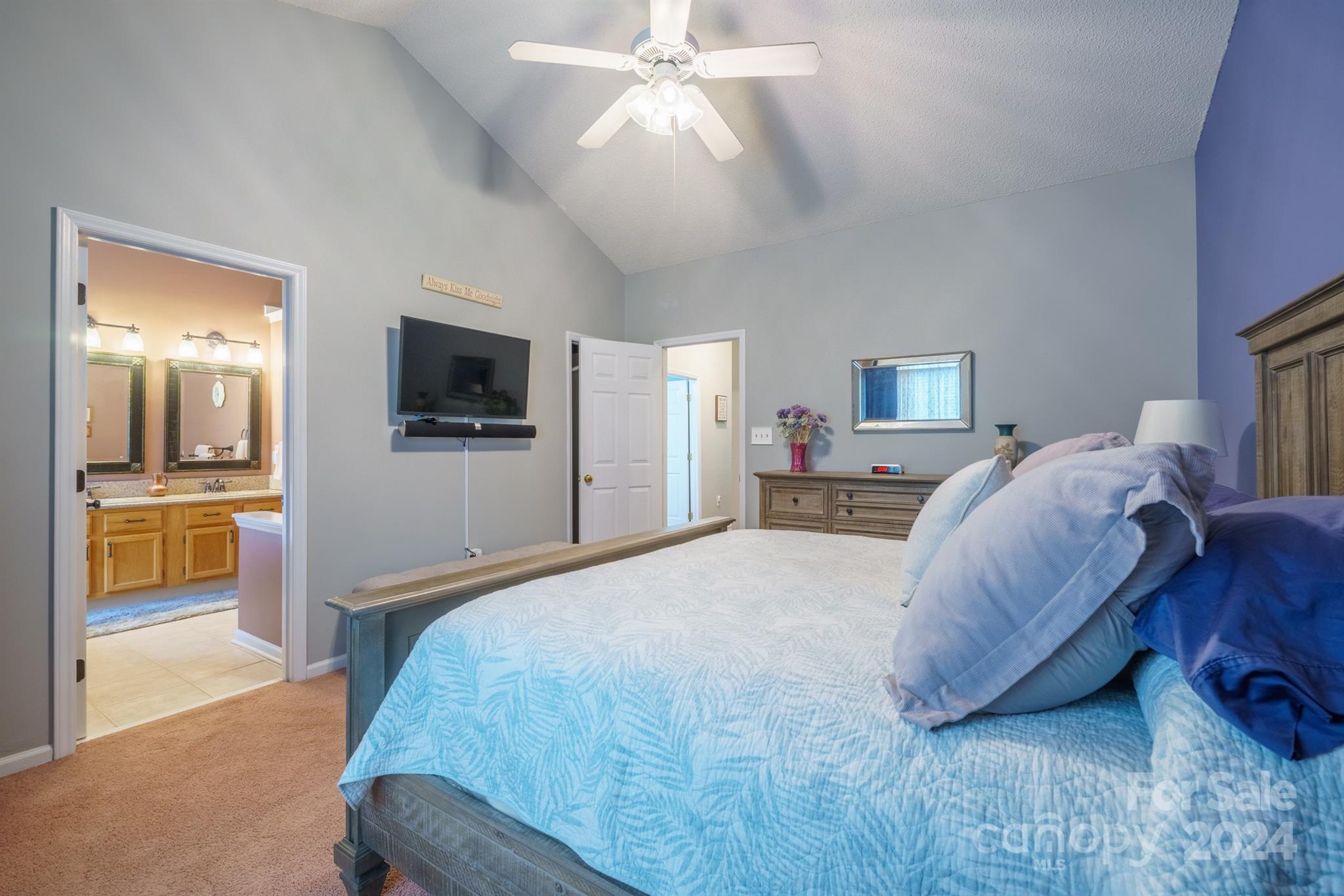 7401 Reedy Creek Road Charlotte, NC 28215 - Photo 12 of 25 a spacious bedroom with a large bed a flat tv screen and a chandelier