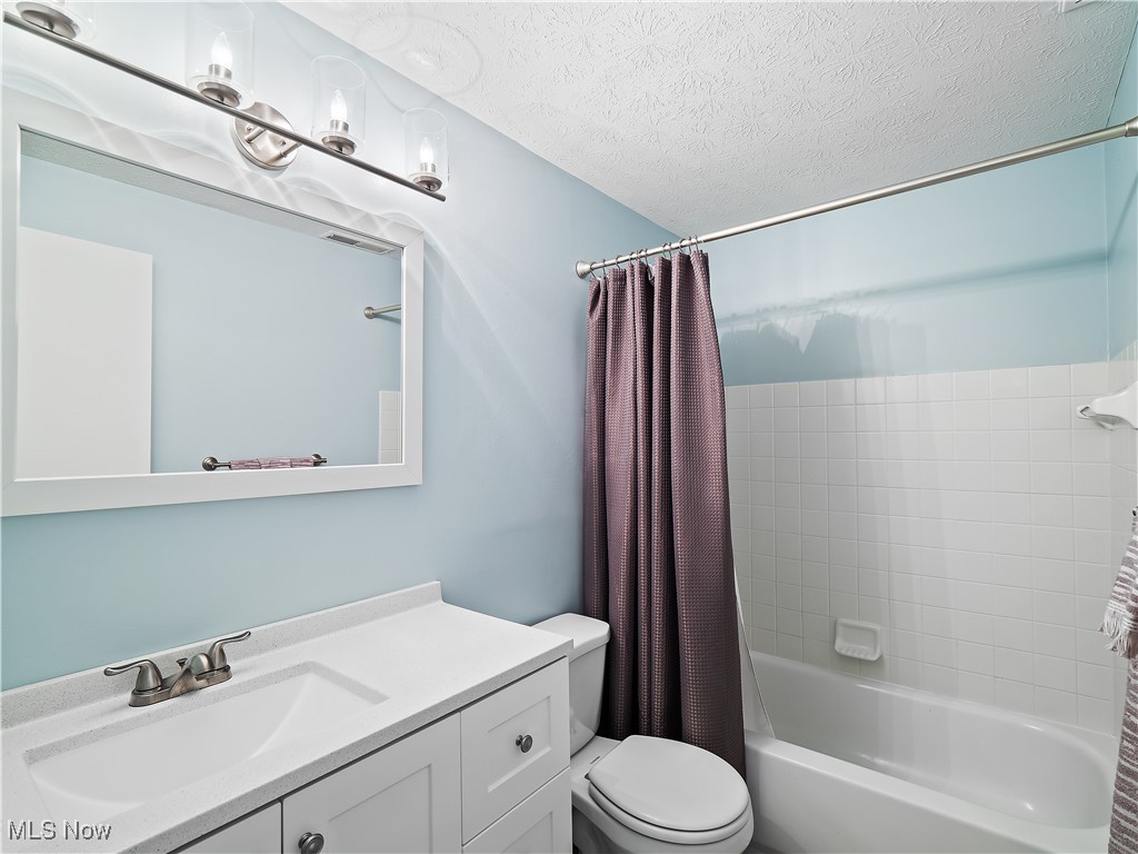 6488 State Road, Unit B5 Cleveland, OH 44134 - Photo 21 of 23 Full bathroom featuring vanity, a textured ceiling, shower / tub combo, and toilet