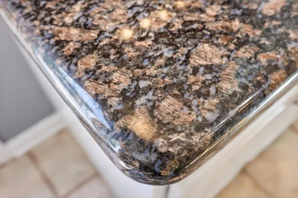 a bathroom with a granite countertop sink two mirror and a sink