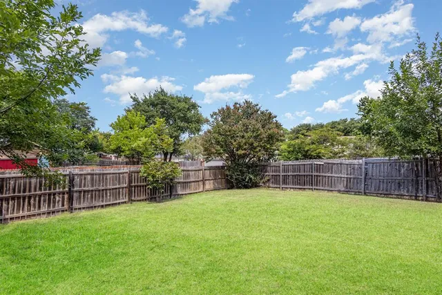 a view of a backyard with a small cabin and wooden fence