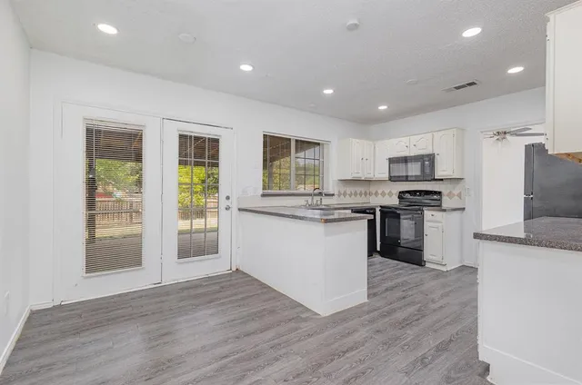 a kitchen with granite countertop appliances cabinets and a sink