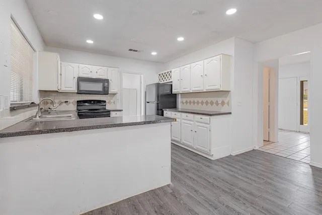 a kitchen with kitchen island a white counter top space cabinets and stainless steel appliances