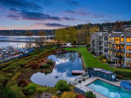an aerial view of residential houses with outdoor space and lake view