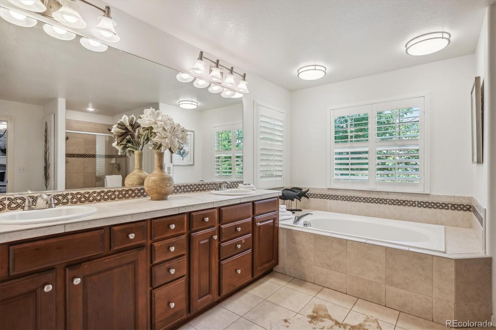 3319 Lynwood Avenue Highlands Ranch, CO 80126 - Photo 21 of 46 a spacious bathroom with a granite countertop double vanity sink large mirror and a bathtub