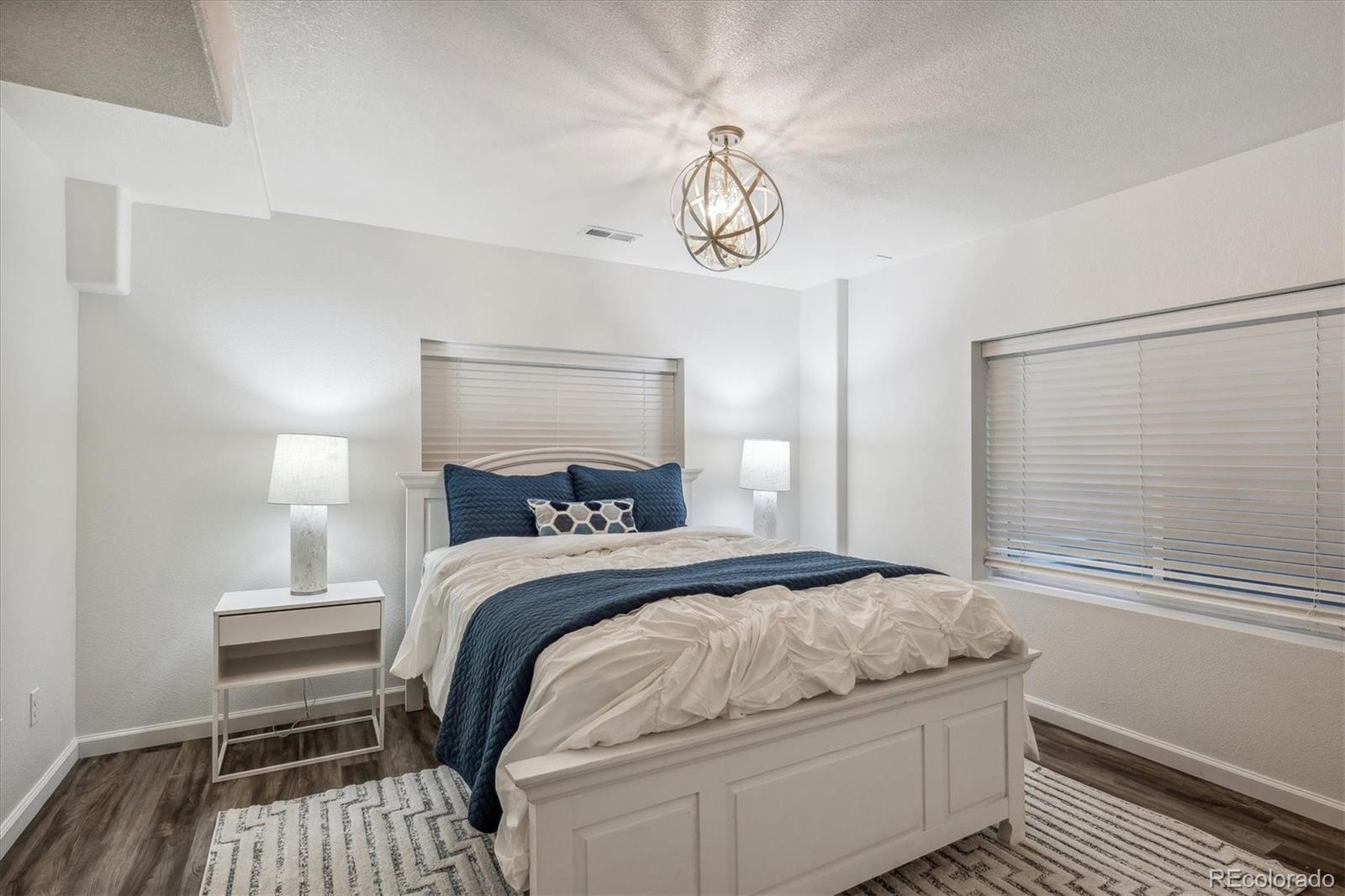3319 Lynwood Avenue Highlands Ranch, CO 80126 - Photo 34 of 46 a bedroom with a bed and a chandelier