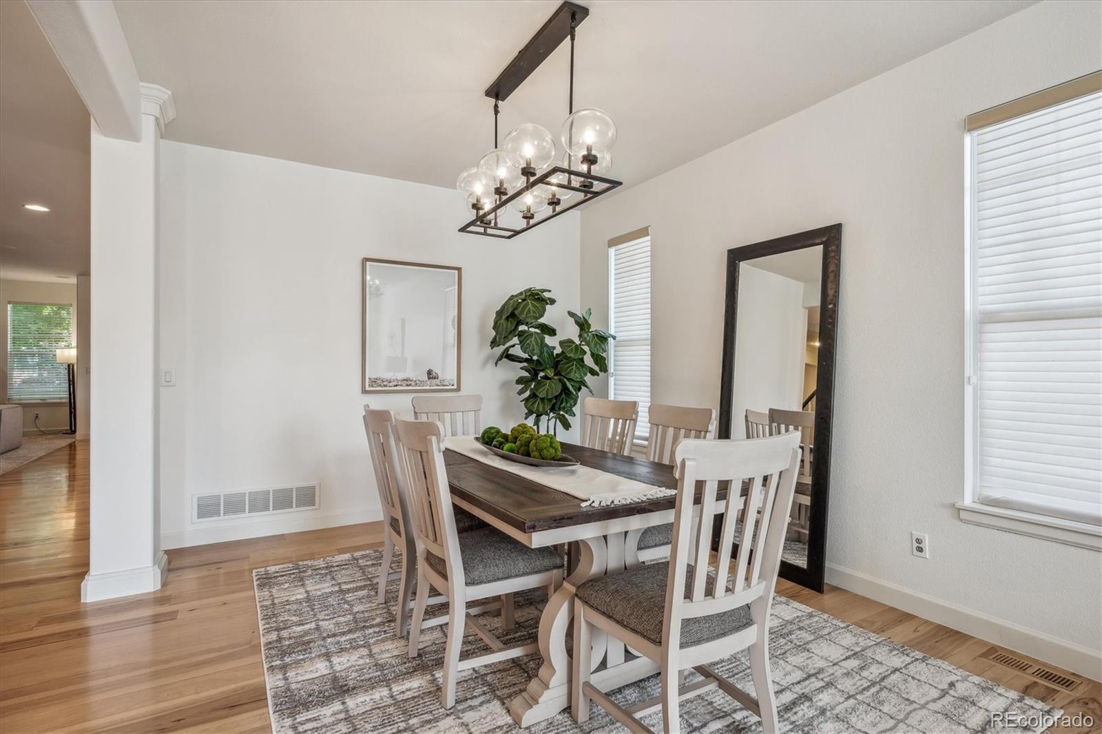 3319 Lynwood Avenue Highlands Ranch, CO 80126 - Photo 5 of 46 a dining room with furniture potted plants and wooden floor