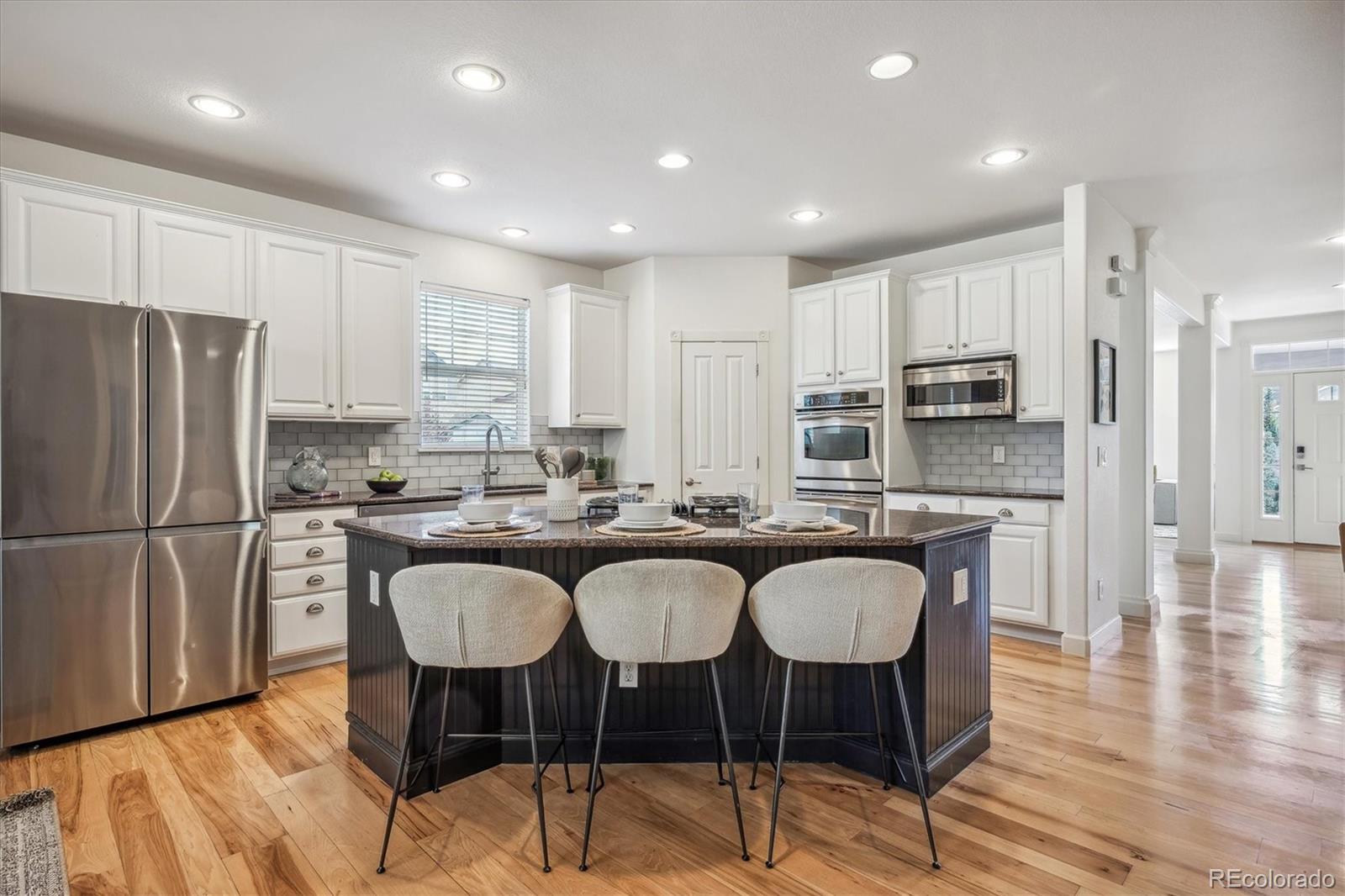 3319 Lynwood Avenue Highlands Ranch, CO 80126 - Photo 8 of 46 a kitchen with refrigerator a sink and chairs