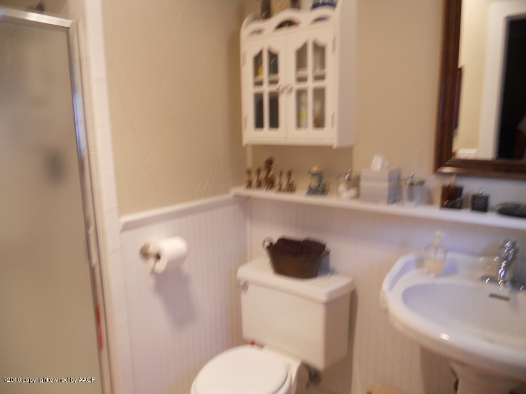 5117 McCarty Boulevard Amarillo, TX 79110 - Photo 11 of 17 a bathroom with a toilet sink and mirror