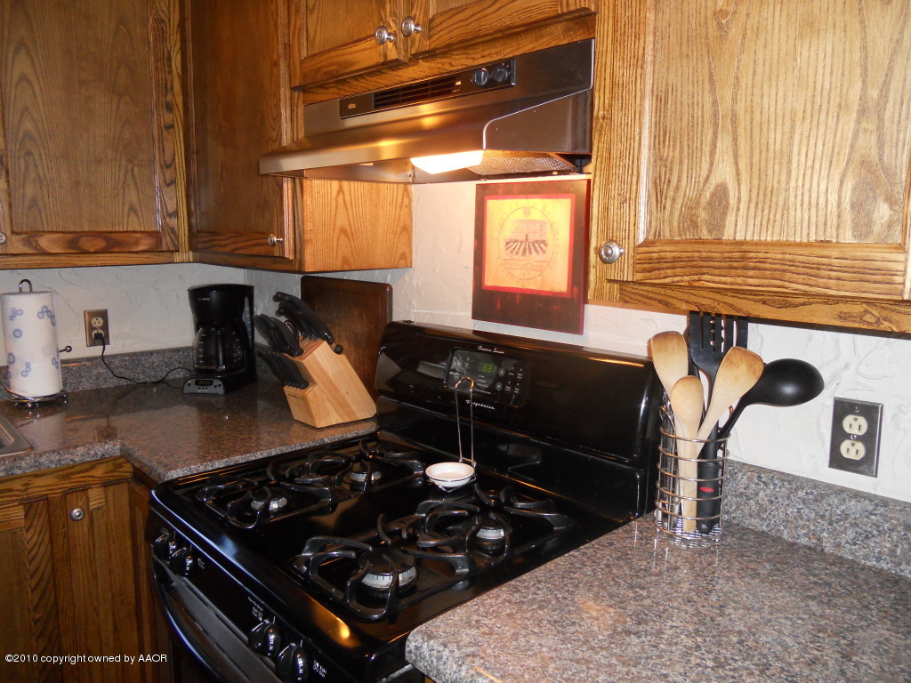 5117 McCarty Boulevard Amarillo, TX 79110 - Photo 6 of 17 a kitchen with a stove and a cabinet