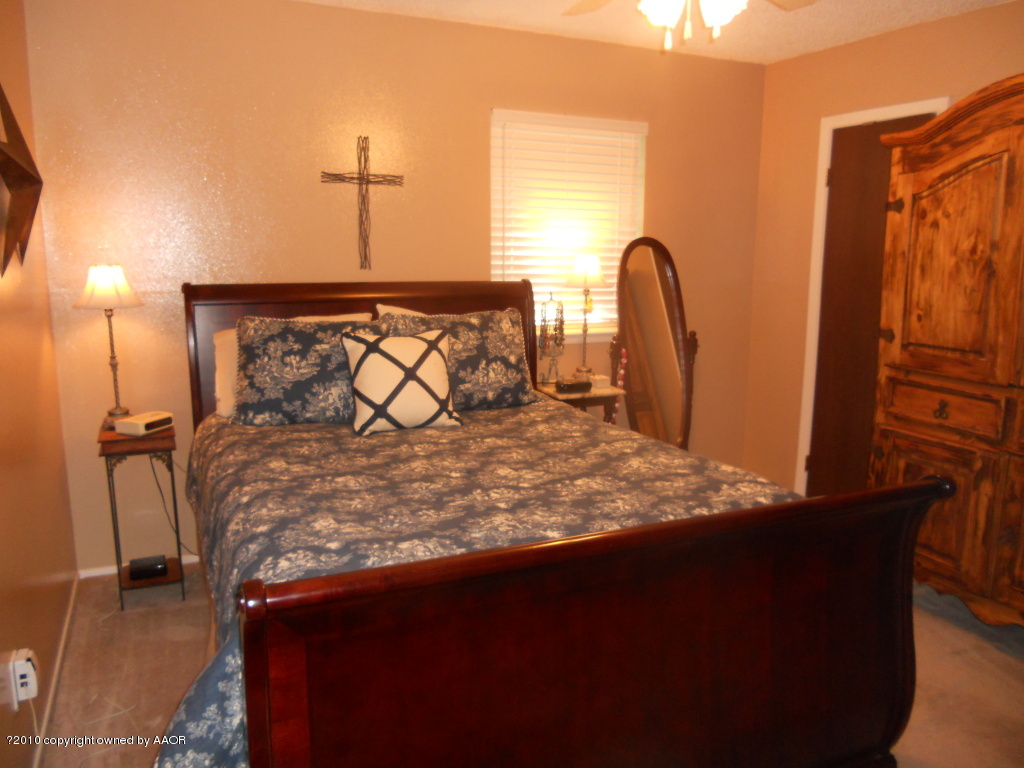 5117 McCarty Boulevard Amarillo, TX 79110 - Photo 10 of 17 a bed sitting in a bedroom next to a window
