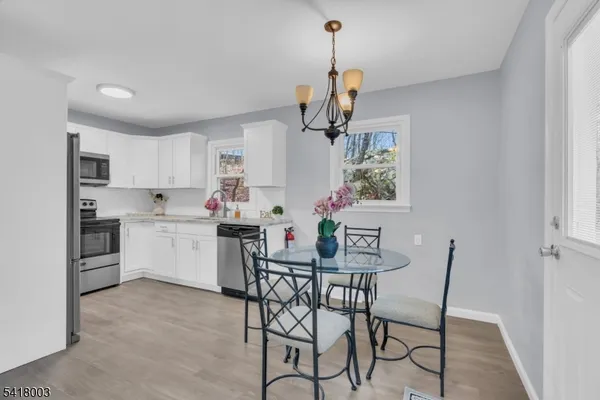a kitchen with stainless steel appliances a kitchen island a stove a table and chairs in it