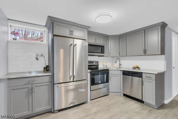 a kitchen with stainless steel appliances white cabinets and a refrigerator