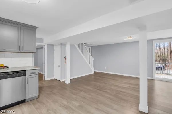 a view of an empty room with wooden floor and cabinets