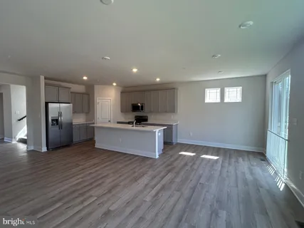 a view of kitchen with refrigerator stove and wooden floor
