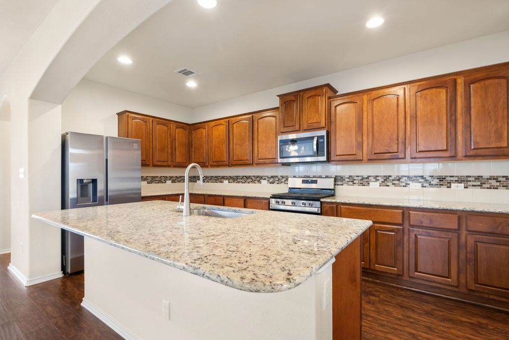 3473 Pauling Loop Round Rock, TX 78665 - Photo 11 of 33 a kitchen with stainless steel appliances granite countertop a sink refrigerator and cabinets