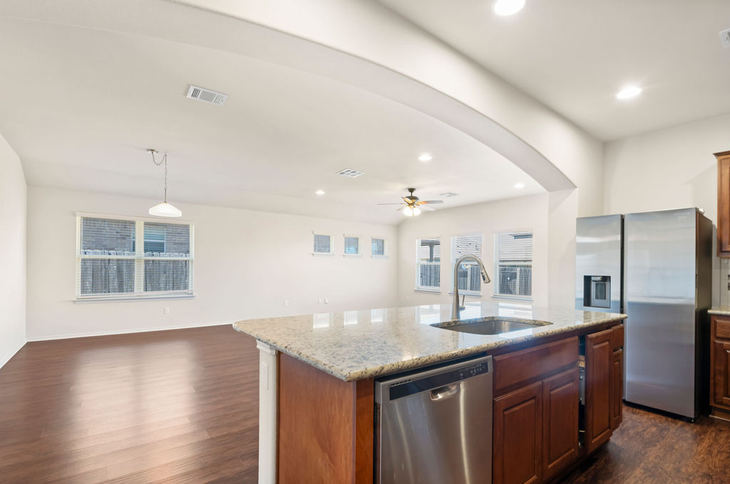 3473 Pauling Loop Round Rock, TX 78665 - Photo 33 of 33 a kitchen with stainless steel appliances granite countertop a sink a stove and a wooden floors