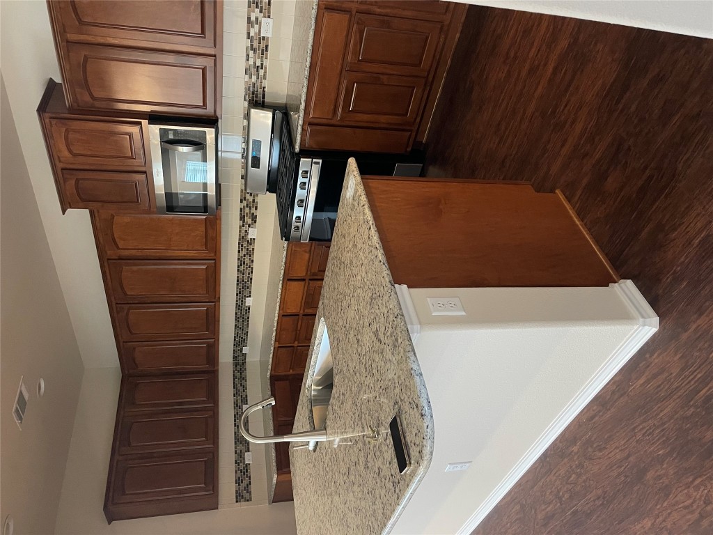 3473 Pauling Loop Round Rock, TX 78665 - Photo 8 of 26 a kitchen with stainless steel appliances granite countertop a sink stove and microwave