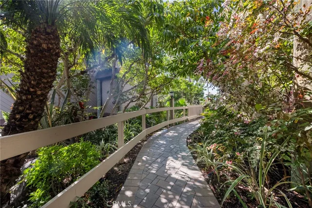 a view of a pathway with a flower garden