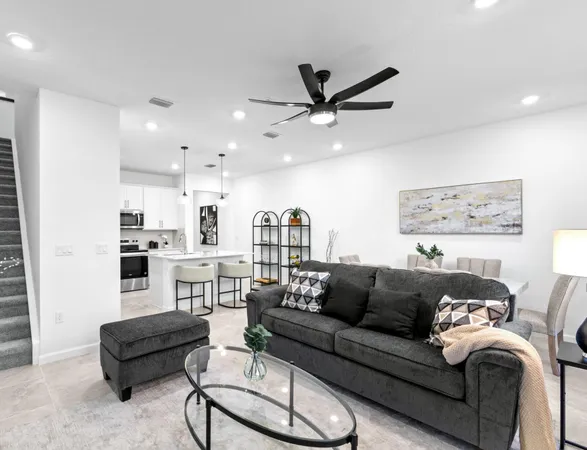a living room with furniture and a view of kitchen