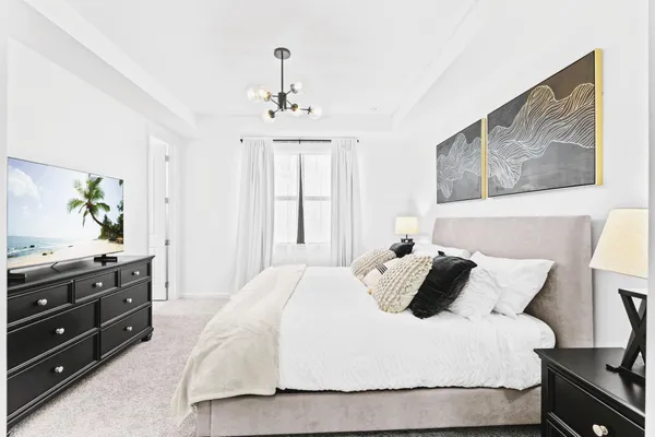 a bedroom with a bed and dresser with mirror