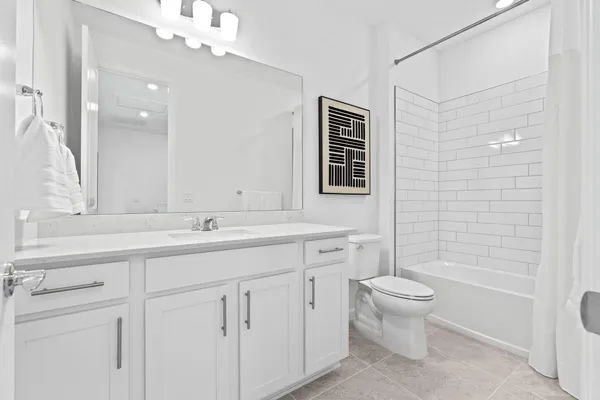 a bathroom with a double vanity sink a toilet and a shower