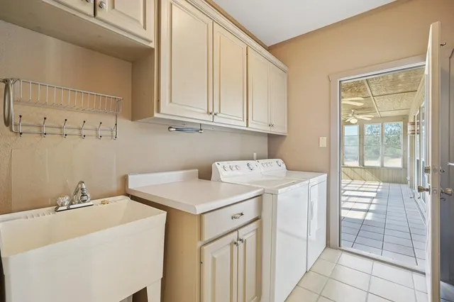 an empty room with chandelier fan and windows