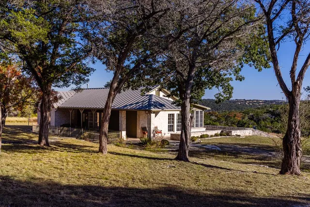 a view of a house with a tree in the yard