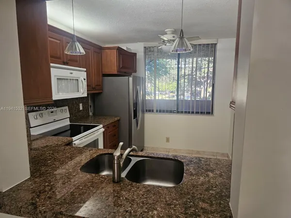 a kitchen with a sink a counter top space and cabinets