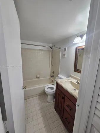 a bathroom with a granite countertop toilet a sink and a mirror