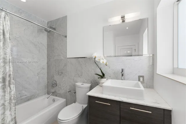 a bathroom with a sink toilet vanity and shower