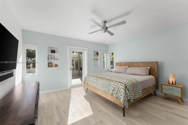 a bedroom with a large bed a flat tv screen and dresser