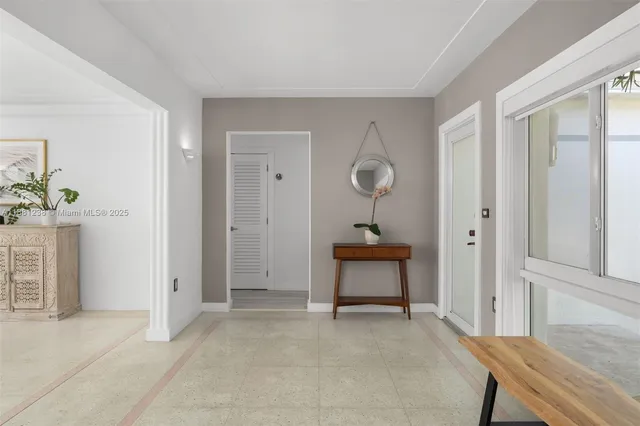 a view of a room with a bench mirror and windows