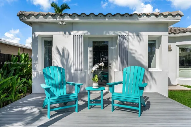 a view of a chair and tables in the patio in front of a house