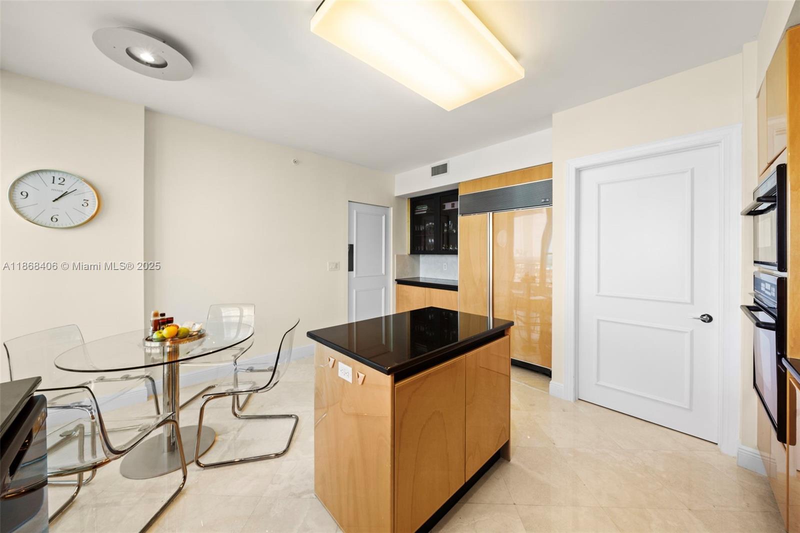 781 Crandon Boulevard, Unit 1802 Key Biscayne, FL 33149 - Photo 12 of 59 a kitchen with stainless steel appliances granite countertop a sink and a refrigerator