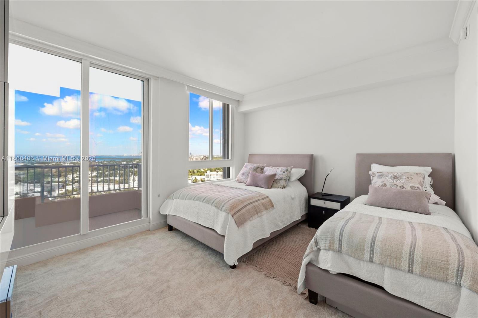 781 Crandon Boulevard, Unit 1802 Key Biscayne, FL 33149 - Photo 17 of 59 a spacious bedroom with two beds and a large window